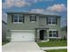 Two-story house with green exterior, white garage door, and landscaping at 2994 Salisbury Ave, Haines City, FL 33844