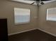 Simple bedroom with two windows, dark floor, and ceiling fan at 303 Cricket Hollow Ln, Eustis, FL 32726