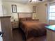 Spacious bedroom with a wooden bed frame and dark brown bedding at 303 Cricket Hollow Ln, Eustis, FL 32726