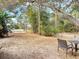 Large backyard with mature trees and a small patio area at 3054 Shallowford St, Deltona, FL 32738