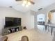 Bright living room featuring a large TV, built-in shelving, and a view into the adjacent kitchen at 3054 Shallowford St, Deltona, FL 32738