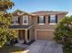 Two-story house with brown siding, shutters, and a two-car garage at 308 Willowbay Ridge St, Sanford, FL 32771