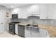 Renovated kitchen, featuring granite countertops, stainless steel appliances, and white shaker cabinets at 360 Gleneagles Dr, New Smyrna Beach, FL 32168