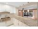 Modern kitchen with granite countertops, stainless steel appliances, and white cabinets at 360 Gleneagles Dr, New Smyrna Beach, FL 32168