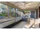 Bright screened porch with wood-look flooring and ceiling fan, overlooking backyard at 360 Gleneagles Dr, New Smyrna Beach, FL 32168