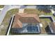 Aerial view of a tan-roofed home with a screened-in pool and detached garage within a white privacy fence at 40 Lantana Dr, Debary, FL 32713