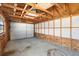 Interior view of a garage with a garage door, concrete floor, exposed rafters and window to the left at 40 Lantana Dr, Debary, FL 32713