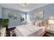 This primary bedroom boasts dark floors, an area rug, and blue walls perfect for a good night's sleep at 413 Country Cottage Ln, Winter Garden, FL 34787