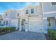 Two-story townhome with gray siding, paver driveway, and landscaping at 4708 Tribute Trl, Kissimmee, FL 34746