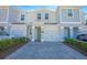 Two-story townhome with gray siding, paver driveway, and landscaping at 4708 Tribute Trl, Kissimmee, FL 34746