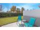 Private patio with two teal chairs and small glass table at 4708 Tribute Trl, Kissimmee, FL 34746