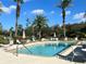 Community pool with lounge chairs and umbrellas at 4865 Cypress Woods Dr # 2109, Orlando, FL 32811