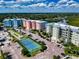 Aerial view of community showing waterfront condos, boat docks, tennis court, and parking at 5 Riverwalk Dr # 301, New Smyrna Beach, FL 32169