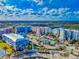 Expansive aerial view of a community with colorful condos, tennis courts, and lush landscaping near the water at 5 Riverwalk Dr # 301, New Smyrna Beach, FL 32169