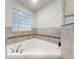 Bathroom featuring a corner soaking tub with jets and glass block window at 5 Riverwalk Dr # 301, New Smyrna Beach, FL 32169