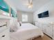 Well-lit bedroom featuring a ceiling fan, wall-mounted TV, and a bright coastal aesthetic at 5 Riverwalk Dr # 301, New Smyrna Beach, FL 32169