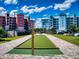 Enjoy community bocce ball with a manicured court between colorful condo buildings under a bright blue, partly cloudy sky at 5 Riverwalk Dr # 301, New Smyrna Beach, FL 32169