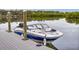 Dock with modern speed boat and tranquil waterway views at 5 Riverwalk Dr # 301, New Smyrna Beach, FL 32169