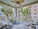 Relaxing covered patio with comfortable seating, a ceiling fan, and views of lush palm trees at 5 Riverwalk Dr # 301, New Smyrna Beach, FL 32169