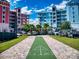 Enjoy community shuffleboard between colorful condo buildings under a bright blue, partly cloudy sky at 5 Riverwalk Dr # 301, New Smyrna Beach, FL 32169