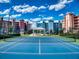 Play tennis on this community court with recreation pavilion, colorful condos and beautiful partly cloudy sky in the background at 5 Riverwalk Dr # 301, New Smyrna Beach, FL 32169