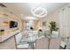 Modern dining room with glass table, white chairs, and contemporary lighting at 5452 Misty Oak Cir, Davenport, FL 33837