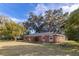 Side view of brick ranch house with mature trees at 646 Palm Dr, Oviedo, FL 32765