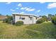 Rear view of a mobile home with a tidy yard and landscaping at 711 Dolphin Dr, Tavares, FL 32778