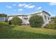 Side view of a mobile home with well-maintained landscaping at 711 Dolphin Dr, Tavares, FL 32778