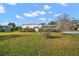 Mobile home with a large front yard and mature landscaping at 711 Dolphin Dr, Tavares, FL 32778