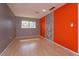 Bedroom with orange accent wall and light hardwood floors at 7482 Canford Ct # 9, Winter Park, FL 32792