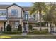 Two story townhouse with landscaping and walkway at 8136 Tavistock Lakes Blvd, Orlando, FL 32827