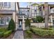 Two-story townhouse with teal door and landscaping at 8136 Tavistock Lakes Blvd, Orlando, FL 32827