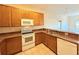 Kitchen with wood cabinets and white appliances at 910 Gran Bahama Blvd # 910, Davenport, FL 33897