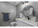 Modern bathroom with white vanity, round mirror, and shower at 1004 Hornbeam St, Oviedo, FL 32765