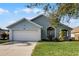 Newly painted light blue house with a white garage and lush green lawn at 1004 Hornbeam St, Oviedo, FL 32765