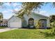 Charming light blue house with a white garage door and well-manicured lawn at 1004 Hornbeam St, Oviedo, FL 32765