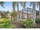 Landscaped backyard with a screened patio and lush greenery at 12161 Obelia Ln, Orlando, FL 32827