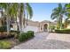 Inviting single-story home with a brick driveway, lush landscaping, and a pristine two-car garage at 12161 Obelia Ln, Orlando, FL 32827