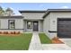 Front entryway with walkway, landscaping, and dark gray garage door at 13680 Sw 40Th Avenue Rd, Ocala, FL 34473