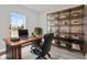 Home office with a large wooden desk, black leather chair, and modern shelving at 13680 Sw 40Th Avenue Rd, Ocala, FL 34473