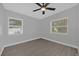 Well-lit bedroom featuring wood-look tile floors and two windows at 145 Verbena Dr, Orlando, FL 32807