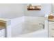 Corner bathtub with gray counter tops and white cabinetry at 15550 Avenue Of The Arbors, Winter Garden, FL 34787