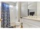 Bathroom with a tub shower combination, white vanity, and patterned shower curtain at 15550 Avenue Of The Arbors, Winter Garden, FL 34787