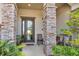 Inviting front porch with stone pillars and landscaping at 15550 Avenue Of The Arbors, Winter Garden, FL 34787