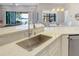 Modern kitchen with stainless steel sink, white cabinets and breakfast bar at 15550 Avenue Of The Arbors, Winter Garden, FL 34787