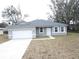 Newly constructed home with gray exterior, white garage door, and landscaping at 16391 Sw 17Th Terrace Rd, Ocala, FL 34473