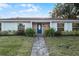 Updated light gray home with a blue door and well-manicured lawn at 1818 Foxboro Dr, Orlando, FL 32812