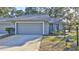 Gray exterior of a single story home with a two-car garage and well-maintained landscaping at 1890 Silver Fern Dr, Port Orange, FL 32128