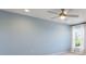 Light blue-walled bedroom with a ceiling fan and large window at 2025 Havasu Falls Ave, Deland, FL 32724